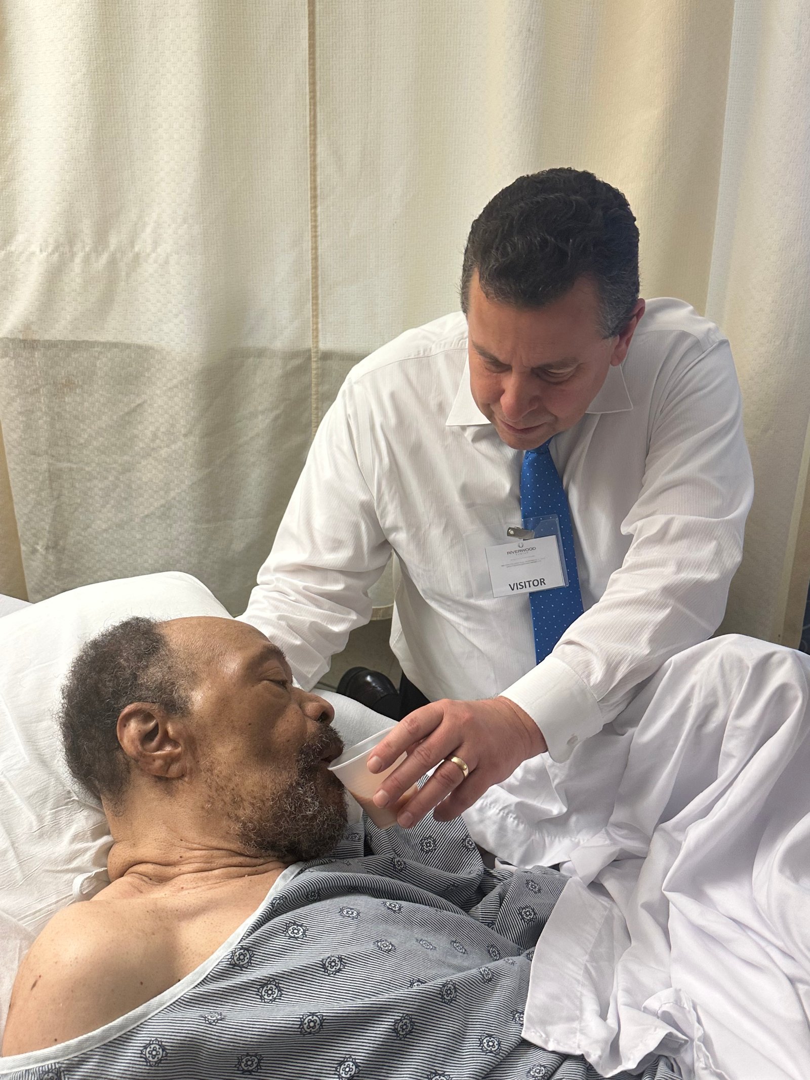 Church volunteer visiting an elderly man in a nursing home
